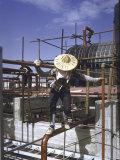 Man Balancing Precariously on Pipe at the Island's Only Oil Refinery
