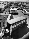 View of Newly Built Houses Jammed Side by Side  Divided by a Street Clogged with Moving Vans