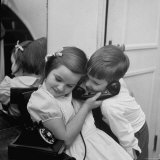 Brother and Sister Sharing the Telephone to Talk to Santa Claus
