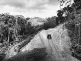 Car Driving Up a Dirt Road in a Rural Area