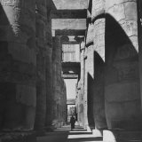 Man Walking Past Huge Carved Columns in Temple of Amon at Karnak in Thebes