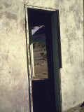 Close Up of Doorway of Old Shelter Through Which Can Be Seen Wooden House in Mojave Desert
