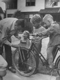 Man Fixing Basket on Bicycle as Children Watch Attentively