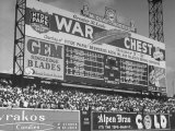 Large Scoreboard Towering over Fans Showing Baseball Scores from Around the League