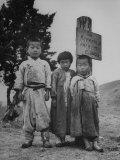 Children Standing in Front of Boundary Zone Sign Written in Russian  English  and Korean