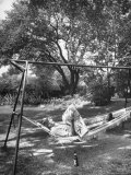 Man Laying in a Hammock with a Beer Beside Him
