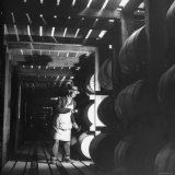 Employee in Warehouse of Jack Daniels Distillery Checking For Leaks in the Barrels