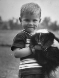 Little Boy Holding His New Friend  a Skunk