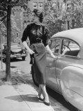 Katherine Cassidy Wearing a Red Fraostmann Wool Skirt and Black Sweater Beneath Black Cardigan
