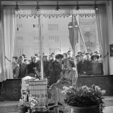 Curious Crowd Watching as a Woman is Made Up with Pig Products at the New Cosmetic Store