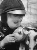 Little Boy Playing with Piglet on Farm in Kansas