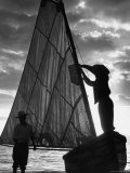 Fisherman Untying the Sail as the Sun Sets over the Water