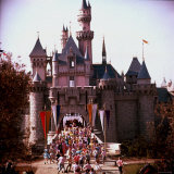Crowds Walking Through Gate of Sleeping Beauty's Castle at Walt Disney's Theme Park  Disneyland