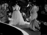 Socialites Wearing Elaborate Evening Dresses and Parading Across Stage During Charity Fashion Show