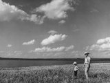 Farmer with Son in Field During Drought