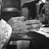 Praying Hands of Monk Churchman Resting on Table During Mass at St Benedict's Abbey