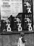 Child Walking Past Posters Advertising Jazz Festival
