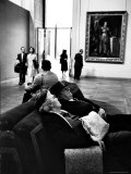 Two Weary American Tourists Resting on Sofa in Gallery of the Louvre