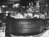 Men Placing Bets on Horses at the Casino Counter
