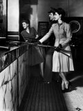 Model Wearing Suit with Pleated Skirt Holding Rifle Standing in Game Gallery with Other Models
