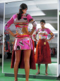 Woman in Miniskirt Holding Up Latest Style Midi Skirt While Looking in Store Mirror