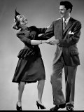 Model Wearing Afternoon Dress and Feathered Hat Dancing with Man Wearing Sport Jacket