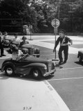 Young Traffic Cop Approaching Boy Swerving His Car Across the Sidewalk