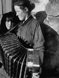 Woman Playing a Russian Button Accordion as Her Young Girl Looks On