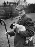 Shepherd Holding a Four Day Old Lamb While Holding a Cane in the Other Hand