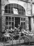 Woman Standing at an Old Fashioned Food Mart with Her Bicycle