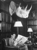 Member Reading Newspaper in Smoking Room at the Harvard Club Beneath a Rhino Head Trophy