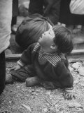 Refugee Child Sitting on Ground