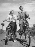 Two Fifteen Year Old Children Riding Their Bicycles Toward the Sea and the Sun