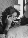 Young Lady Talking on Telephone with a Friend  in Privacy of Her Parent's Bedroom