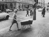 Mother in Miniskirt Pushing Her Baby Carriage Across Cobblestone Street