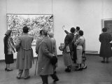 People Looking at a Painting by Artist Jackson Pollack at an American Art Show
