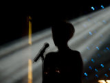 Female Singer and Microphone Silhouetted with Stage Lights