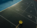 Setting up for a Shot on a Shuffleboard Game on a Cruise Ship