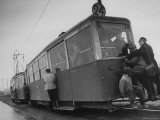 People Hanging Off a Streetcar
