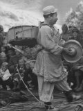 Mongolian Clown Entertaining a Happy Crowd by Marching with a Drum and Symbols