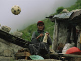 A Soccer Ball Flies over the Head of Woman Who is Knitting Outdoors
