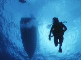 A Silhouetted Diver Descends into Clear Blue Water