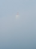 Hazy Clouds in the Sky Obscure a Lighthouse