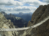A Man Walking Across a Bridge in the Dolemites  Cortina  Italy