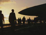 Silhouetted Military Personnel on an Aircraft Carrier at Twilight
