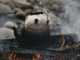 A Kettle of Water Comes to a Boil over a Smoky Campfire
