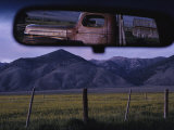 An Old Truck and Barn are Reflected in a Rear-View Mirror