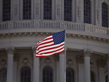 A Backlit American Flag Glows against the Dome of the Capitol Building