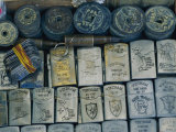 A Tray Full of War Memorabilia Engraved Zippo Lighters  Dog Tags  Bullets  and Ancient Coins