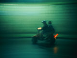 Panned Shot of Two People on a Small Scooter